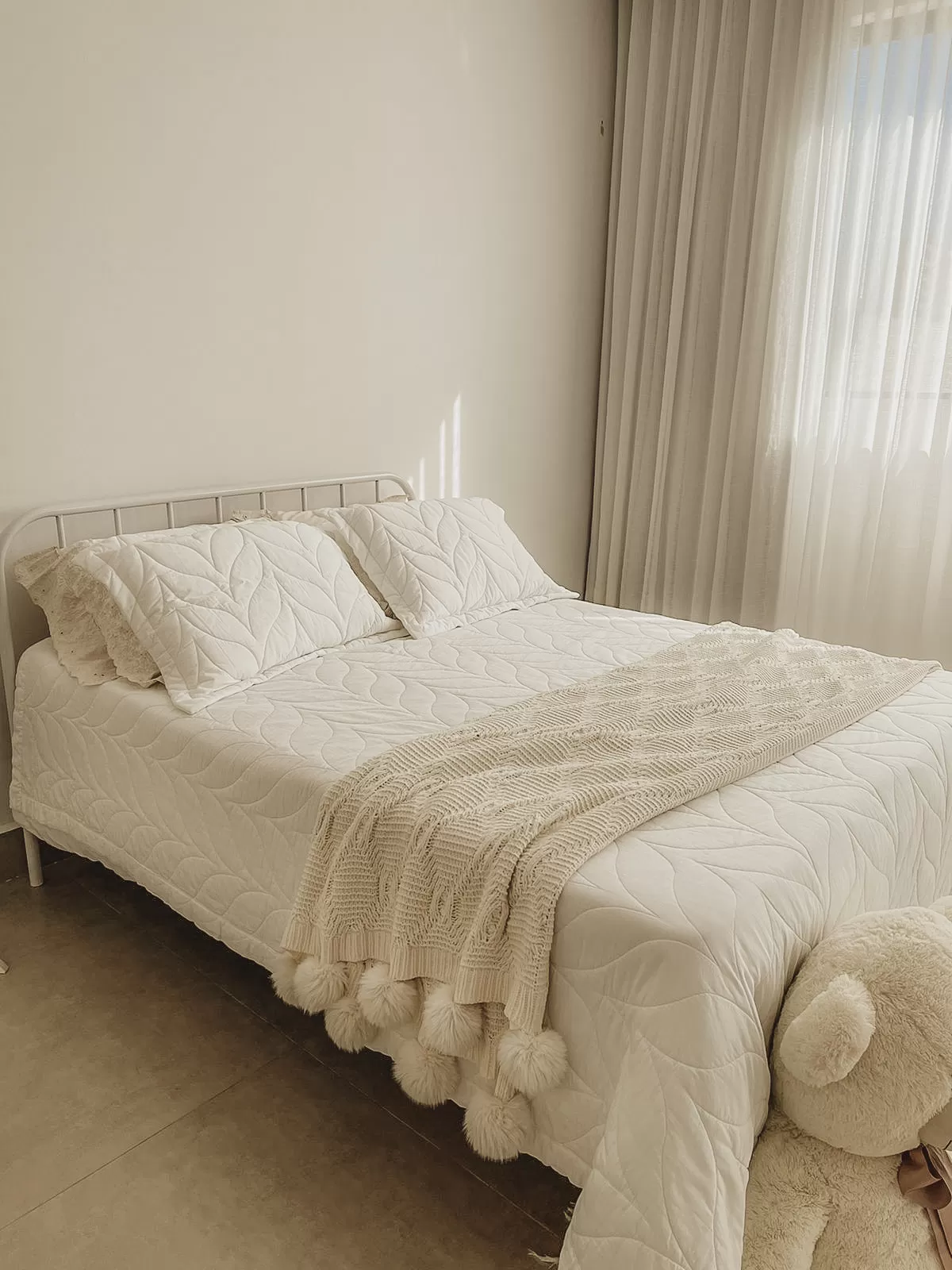 Cama de cenário com tons suaves no Estúdio Malice